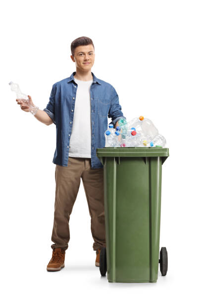 istock Young man behind a bin holding a plastic bottle for recycling 2061899999
