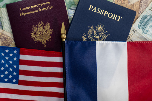Flags and staff of United States and France on passports and international currency