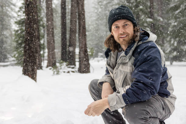 istock A man wearing a blue jacket and a black hat is standing in the snow 2061968496