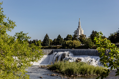 Photo of the Snake River on the North Idaho Falls Greenbelt.  Showing Canadian Geese on the top of the Diversion Dam and the Idaho Falls Mormon/Later Day Saint’s Temple in the background.