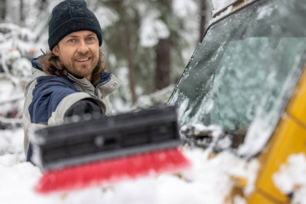 istock A man is smiling and holding a snow brush 2062001318