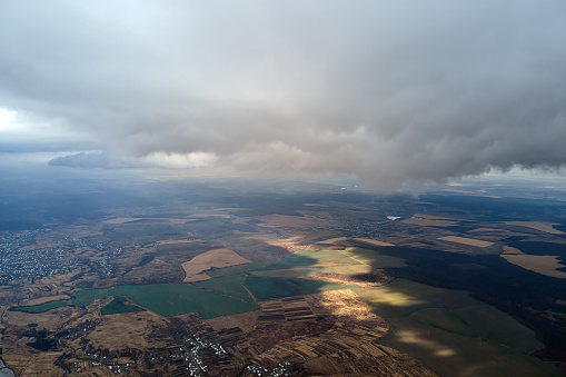 Aerial view from high altitude of earth covered with puffy rainy clouds forming before rainstorm.
