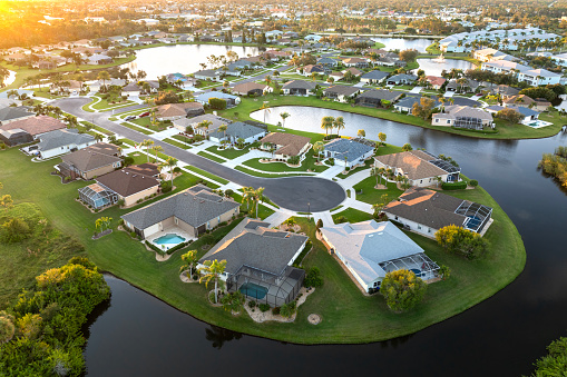 Cul de sac street dead end at sunset and private residential houses in rural suburban sprawl area in North Port, Florida. Upscale suburban homes with large waterfront backyards.