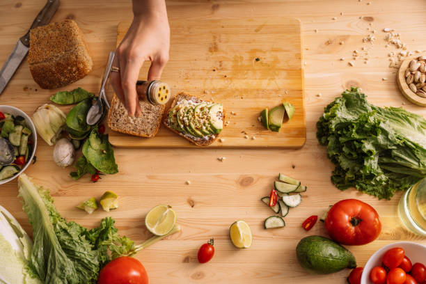 istock Lady preparing a vegetarian sandwich on a wooden table among fresh vegetables 2062071056