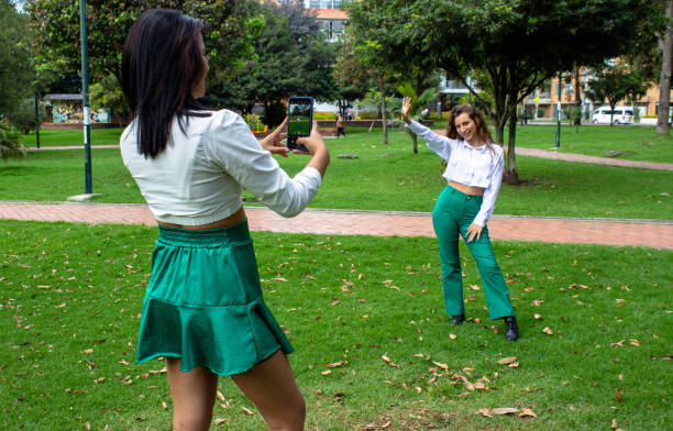 istock two beautiful young women having fun in a public park 2062115951