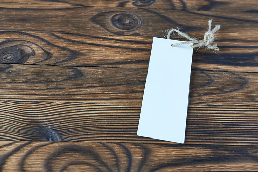 Blank tag on wooden background, copy space for your text.