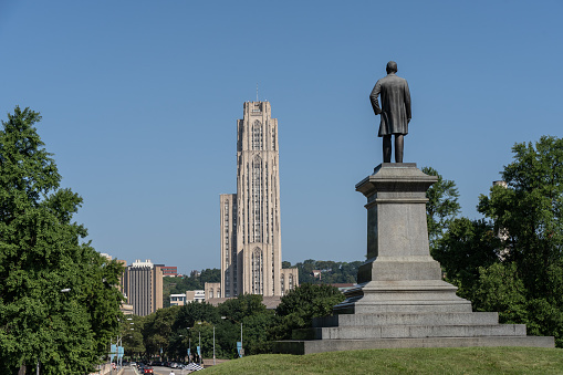 Pittsburgh, Pennsylvania  July 23,2023: A statue of Edward Bigelow outside Phipps Conservatory overlooks Shenley Avenue and the Cathedral of Learning, Pittsburgh University.