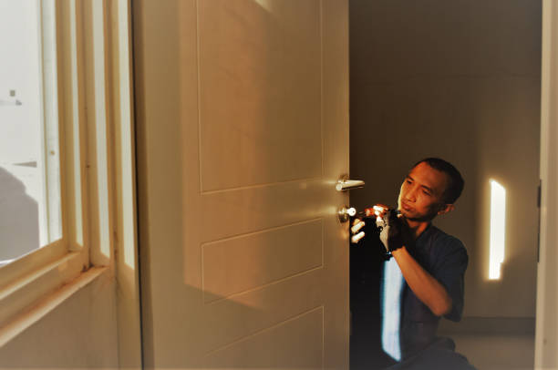 An Asian blue collar worker is repairing the door.