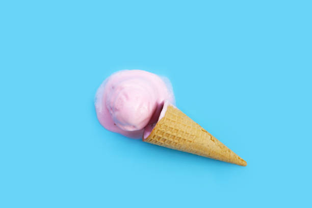 istock Melting ice cream balls with waffle cone on blue background. 2062236945