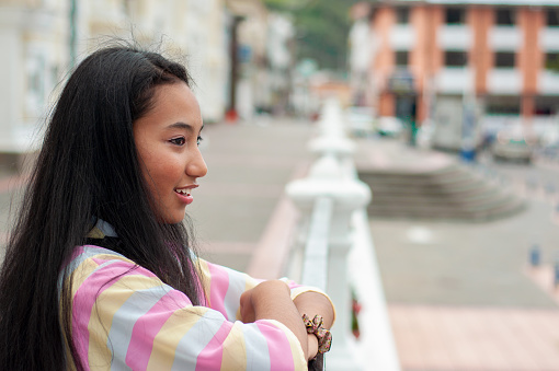 copy space of a young tourist visiting the city square, the young woman admires what is around her with a gesture of contained happiness