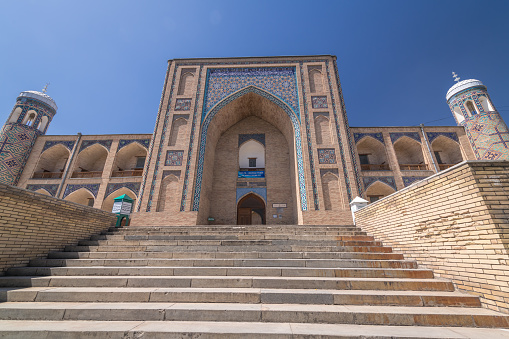 JUNE 26, 2023, TASHKENT, UZBEKISTAN: Decorated arches of the Kukeldash Madrasah next to Chorsu bazaar, Tashkent, Uzbekistan. Text translation from Uzbek: Entrance