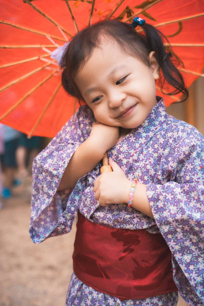 Capturing cultural harmony and childhood tranquility, these adorable 3-year-old Chinese twin baby girls don traditional Japanese Kimonos as they explore and relax in a serene Japanese public park. Their innocent laughter and tiny steps add a touch of joy to the peaceful atmosphere, creating a harmonious blend of Chinese and Japanese traditions.