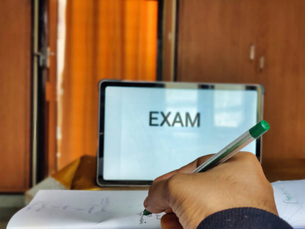 Picture of a person studying preparing for exam with EXAM written on a placard in background