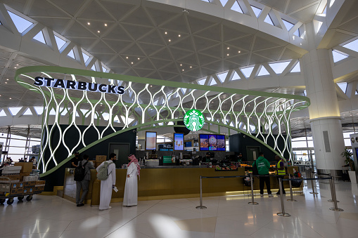 Riyadh, Saudi Arabia - February 25, 2024 : Customers at a Starbucks Coffee in King Khalid International Airport, Riyadh, Saudi Arabia.