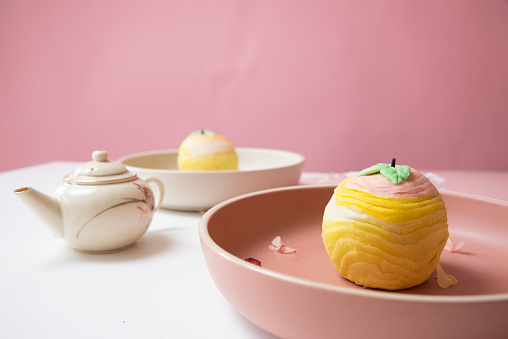 traditional gourmet home made baked teo chew crispy skin egg yolk durian moon cake on cute pink background tea pot concept for Chinese mid autumn festival celebration dessert pastry menu halal food in asian