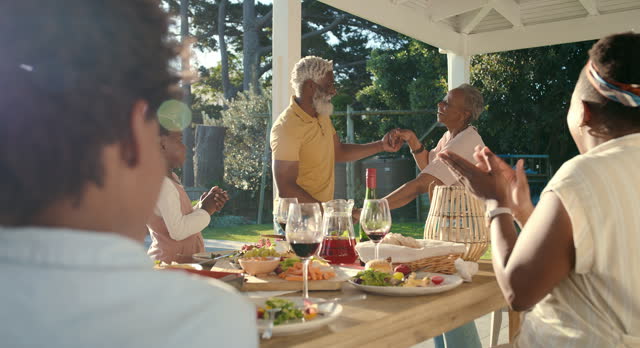 Family, food and grandparents dancing outdoor on patio for party, fun and playful with lunch, energy and celebration together. Black people, generations and festive mood for reunion in home backyard
