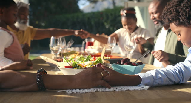 Christian, holding hands or black family praying for food to worship God together for faith or gratitude. Grandparents, outdoor or African people with children for a meal, brunch or lunch with grace