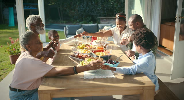 Christian, group or black family praying on food to worship or celebrate God for faith, Easter or gratitude. Home, clapping or grandparents holding hands with African children for meal, love or lunch