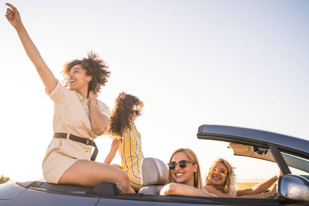 istock Female friends having fun on road trip with car 2062399263