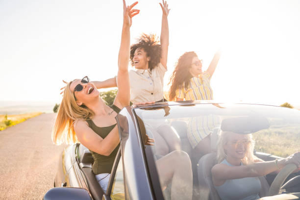 istock Female friends having fun on road trip with car 2062399266