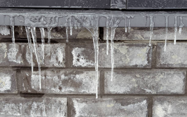 istock Icicles hang from the brick wall of the building 2062399422