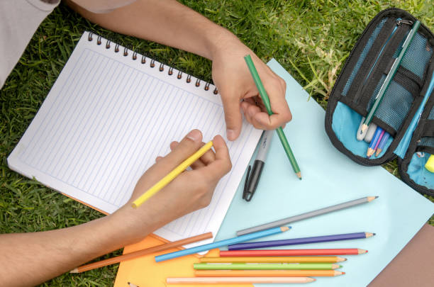 istock A student person writing in a notebook with colored pencils 2062399754