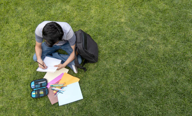 istock A male student sitting on the grass writing in a notebook 2062399804