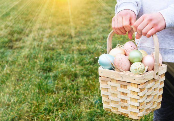 istock Easter basket with eggs in a child's hands. Sun rays 2062458478