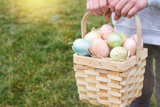 istock Easter basket with eggs in a child's hands. Sun rays 2062458479