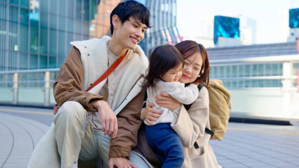 istock Young Japanese Mother Hugging her Daughter while Father Looks On 2062464331