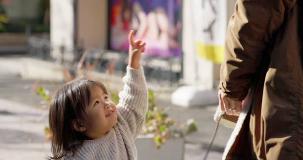 Low angle shot of a three-year-old Japanese girl looking up at her father.