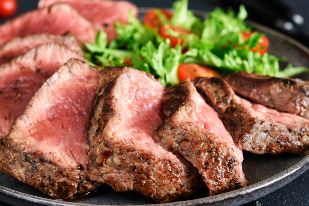 istock Grilled beef with arugula salad and tomatos. 2062474494
