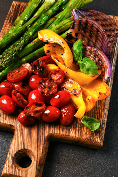 istock Grilled vegetables: asparagus,tomatos,onion on a wooden board on a black background 2062490849