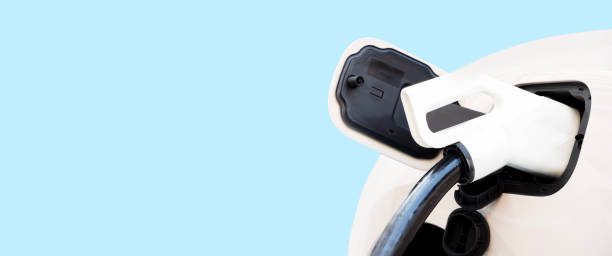 Electric car charging at a charging station is a DC fast charger. blue isolated background. White electric car charging with copy space, Technology electric vehicle concept.