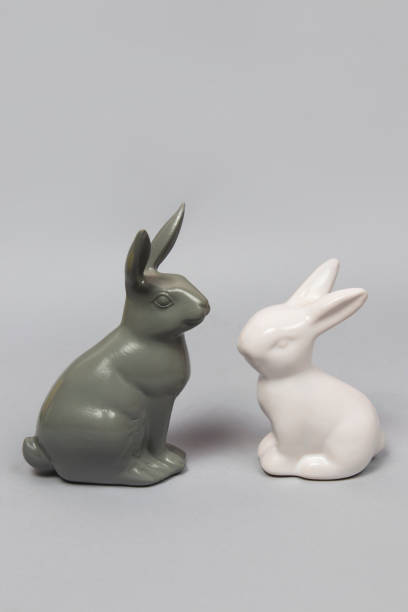 Gray and white ceramic  Easter bunny figurines on a gray background