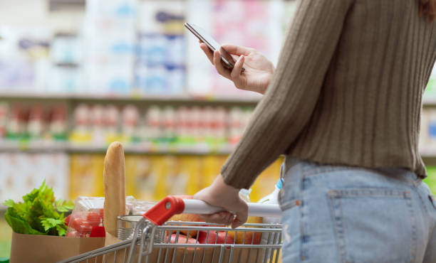istock Woman using her smartphone at the supermarket 2062514588