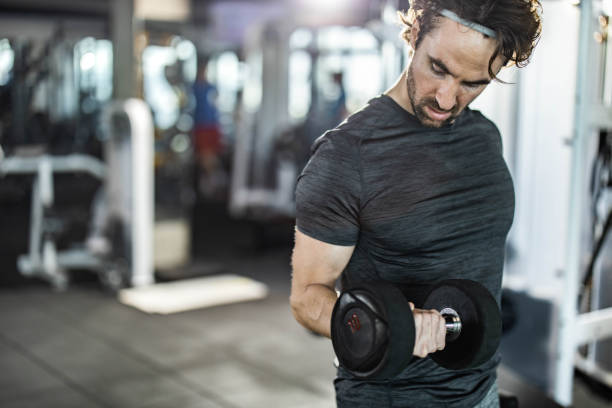 istock Determined athletic man exercising with dumbbell in a gym. 2062535611
