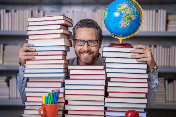 istock education in school library. man bookworm get knowledge. teachers and knowledge day. clever school teacher. bookworm man in classroom. school teacher with book literature. Unleash your inner genius 2062535642