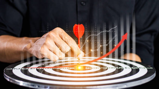 istock Businessman throwing red arrow dart to  target dart board. Setup objectives and target for business investment concept. business investment objective concept Marketing strategies and goals for success 2062549776