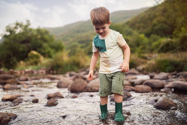 istock Happy little boy playing in the shallow mountain river 2062552713