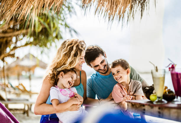 istock Happy parents having fun with their small kids in a beach bar. 2062553231