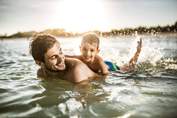 istock Happy single father and son having fun in summer day at sea. 2062553819