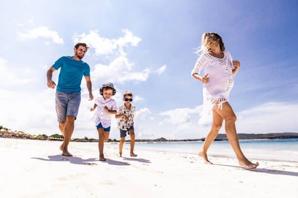 istock Playful family having fun while running on the beach. 2062557051