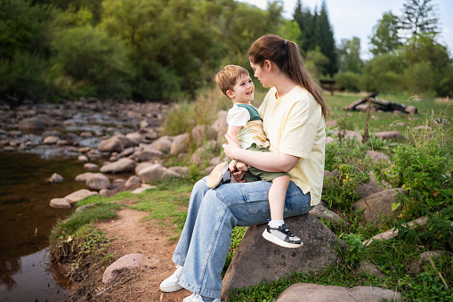 Mom and son enjoying a carefree spring day by the river.