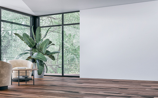 Empty unfurnished modern interior with a large potted plant (strelitzia Nicolai), a set of lounge velvet yellow chairs and a coffee table on parquet hardwood floor in front of large corner windows with garden view and a balcony with a stainless steel fence, a blank white wall background on the other side. 3D rendered image.