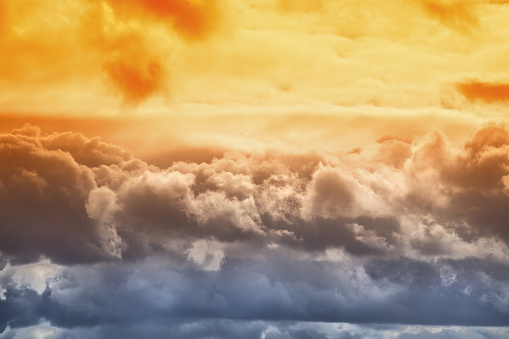 Orange sunlight on clouds in the sky, multicolored blue-orange clouds close-up