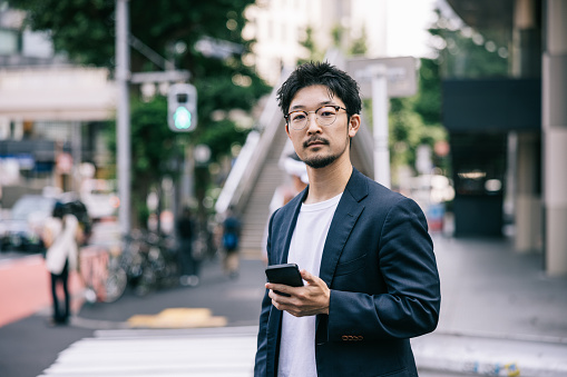 A young businessman stays connected in the city using his smartphone