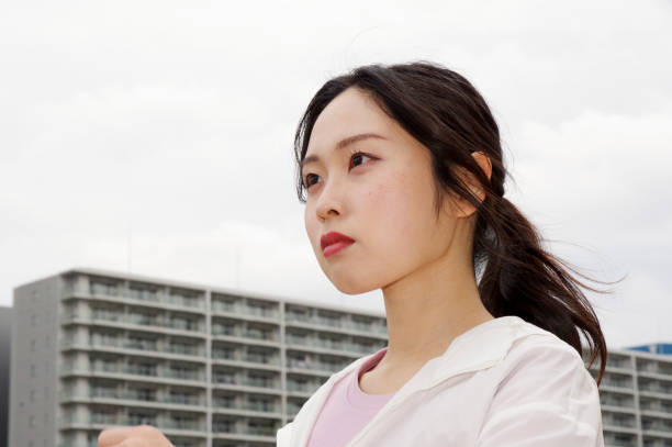 A woman walking along a promenade lined with high-rise residential buildings