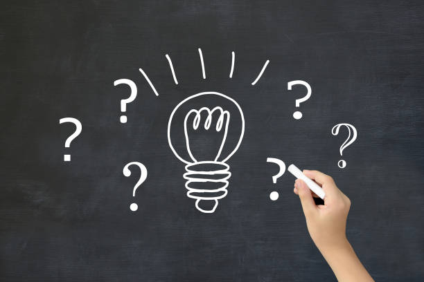 istock Child’s hand drawing light bulb and question marks on blackboard 2062615735