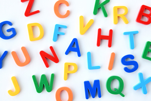 Alphabet blocks arranged at random on white board